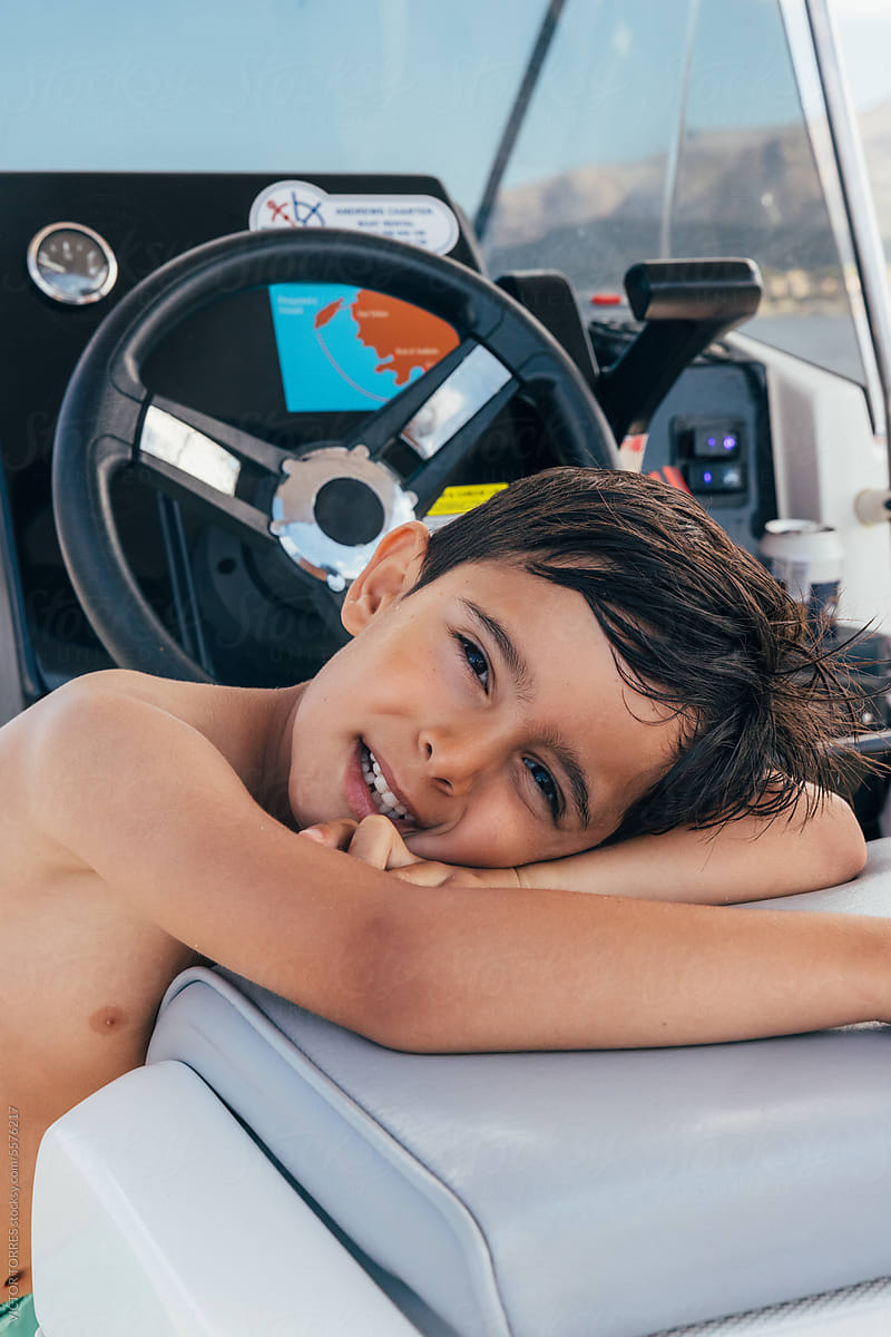 Smiling kid lying on boat seat