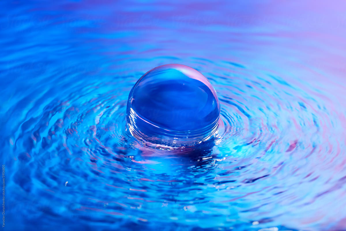 Crystal ball in water with blue and pink gradient effect on surface