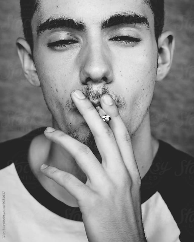 Smoking young man with squinted eyes
