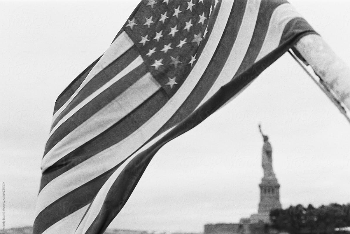 statute of liberty framed by american flag in black and white