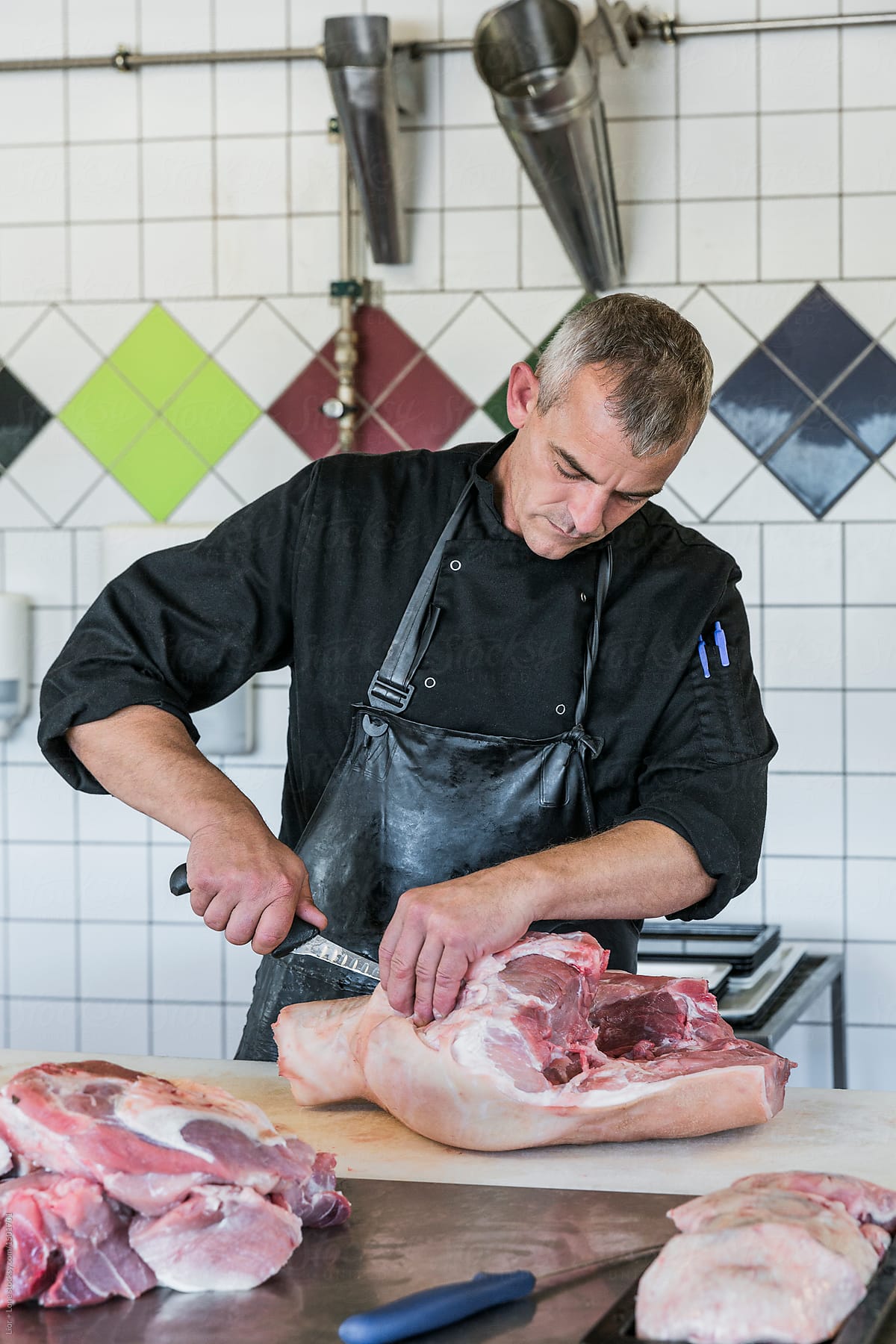 Man butcher working cutting a big piece of meat