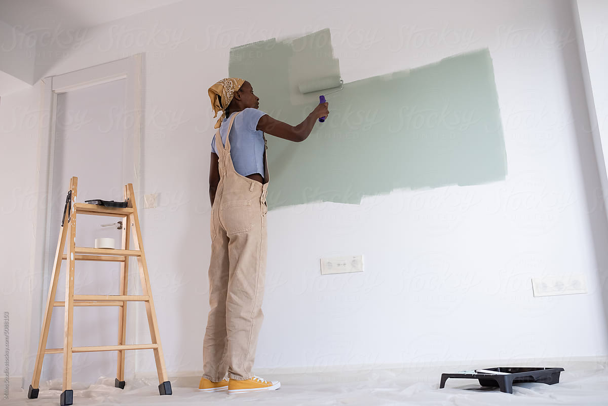 African American female painter changing wall color