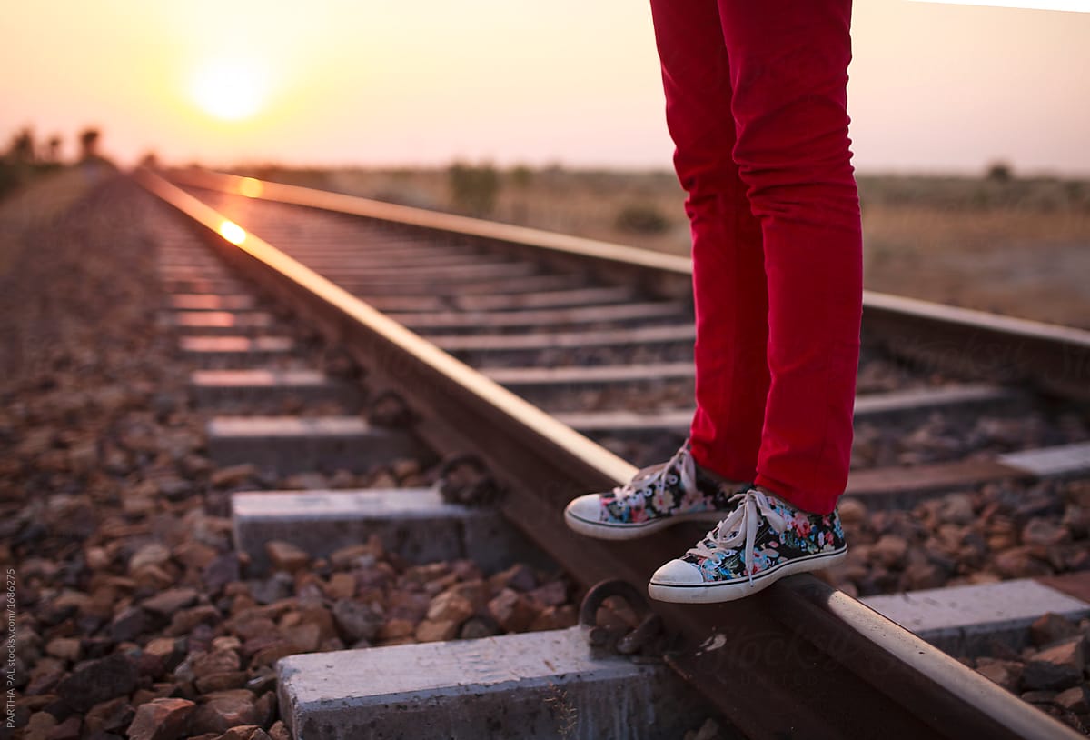 A girl Standing on a rail track