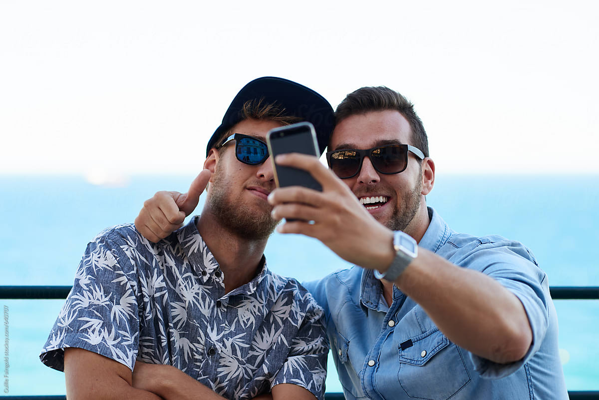 Men taking selfie by sea