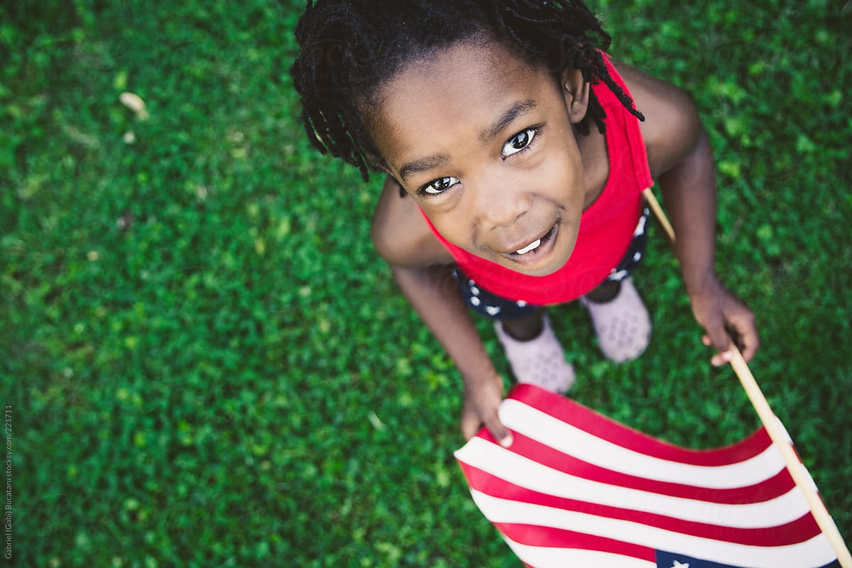 African-American Girl in Red, White and Blue USA Flag Outfit Holding A USA Flag