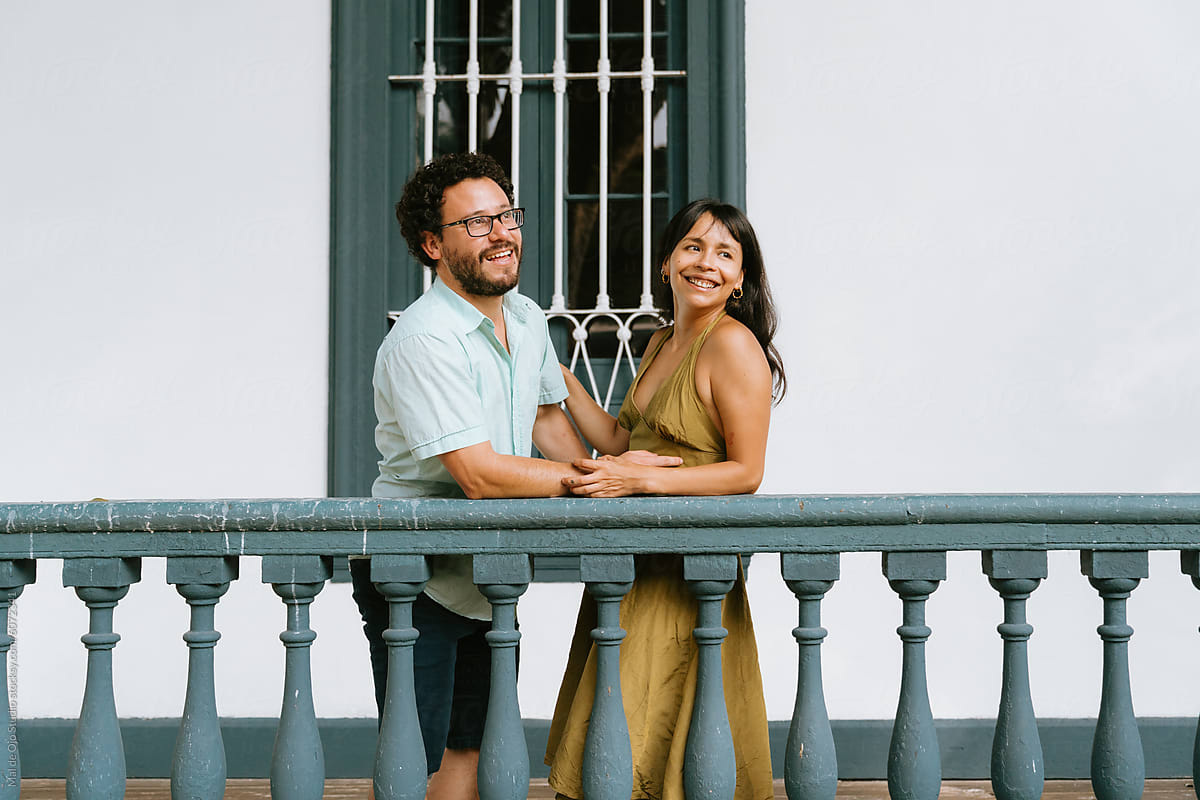 Couple Embracing on a Classic Balcony
