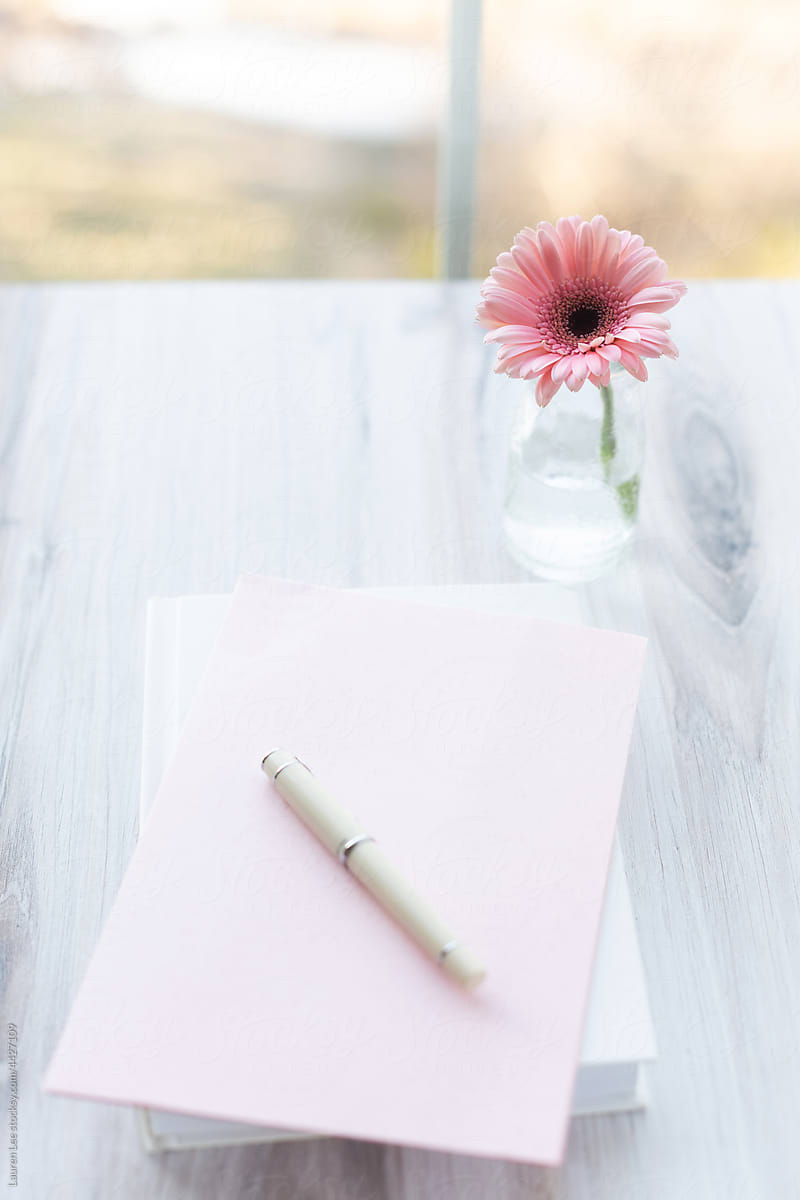Pretty pink flower on wooden table