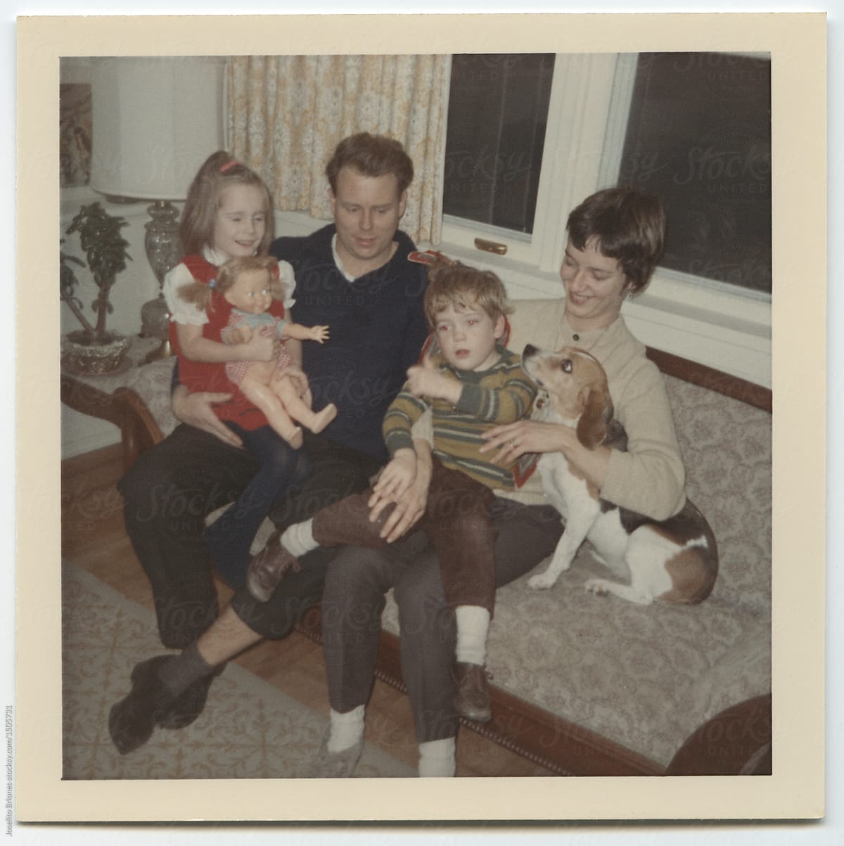 Vintage family photo with pet beagle dog on a sofa a living room