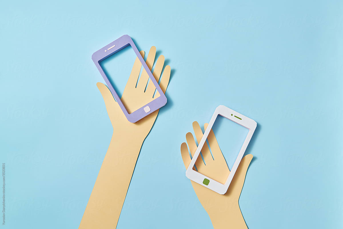 Two papercraft hands with smartphone frames.