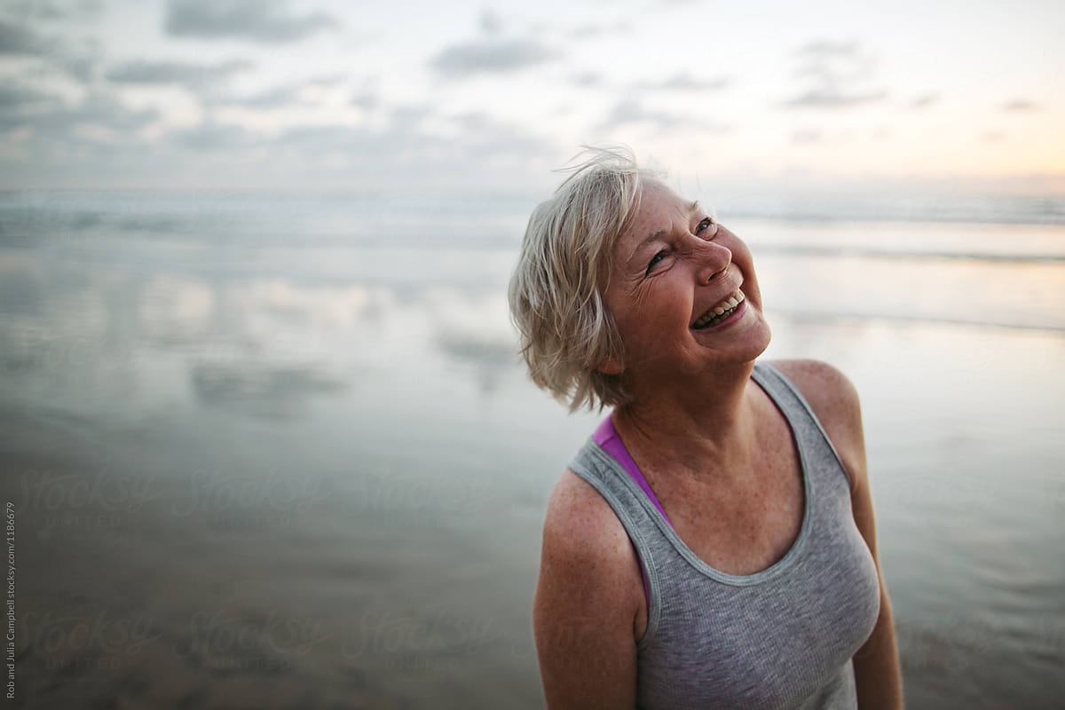 Vibrant Mature Woman Enjoying Herself On The Beach At Sunset By Rob And