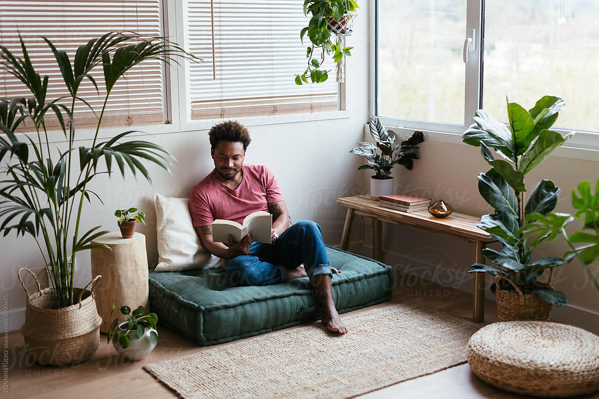 Black man reading book at home