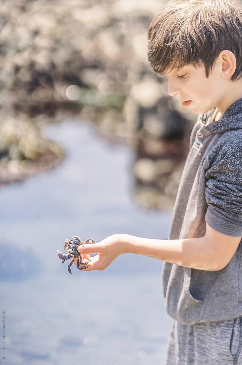 young boy holds crab