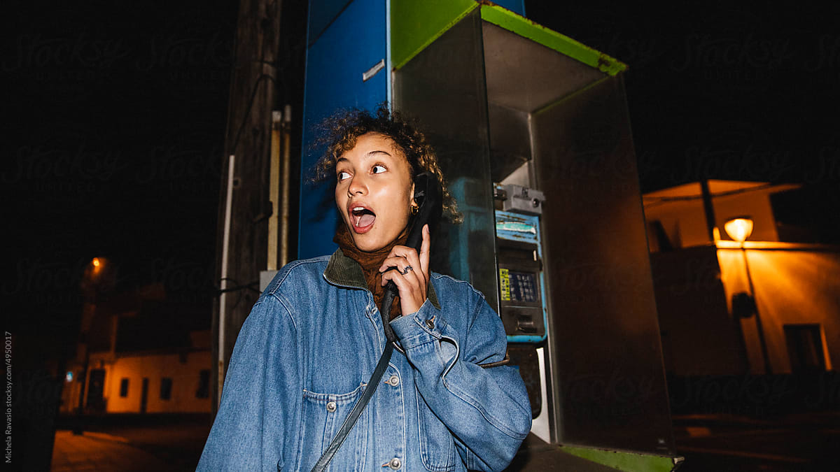 Astounded woman at the phone booth