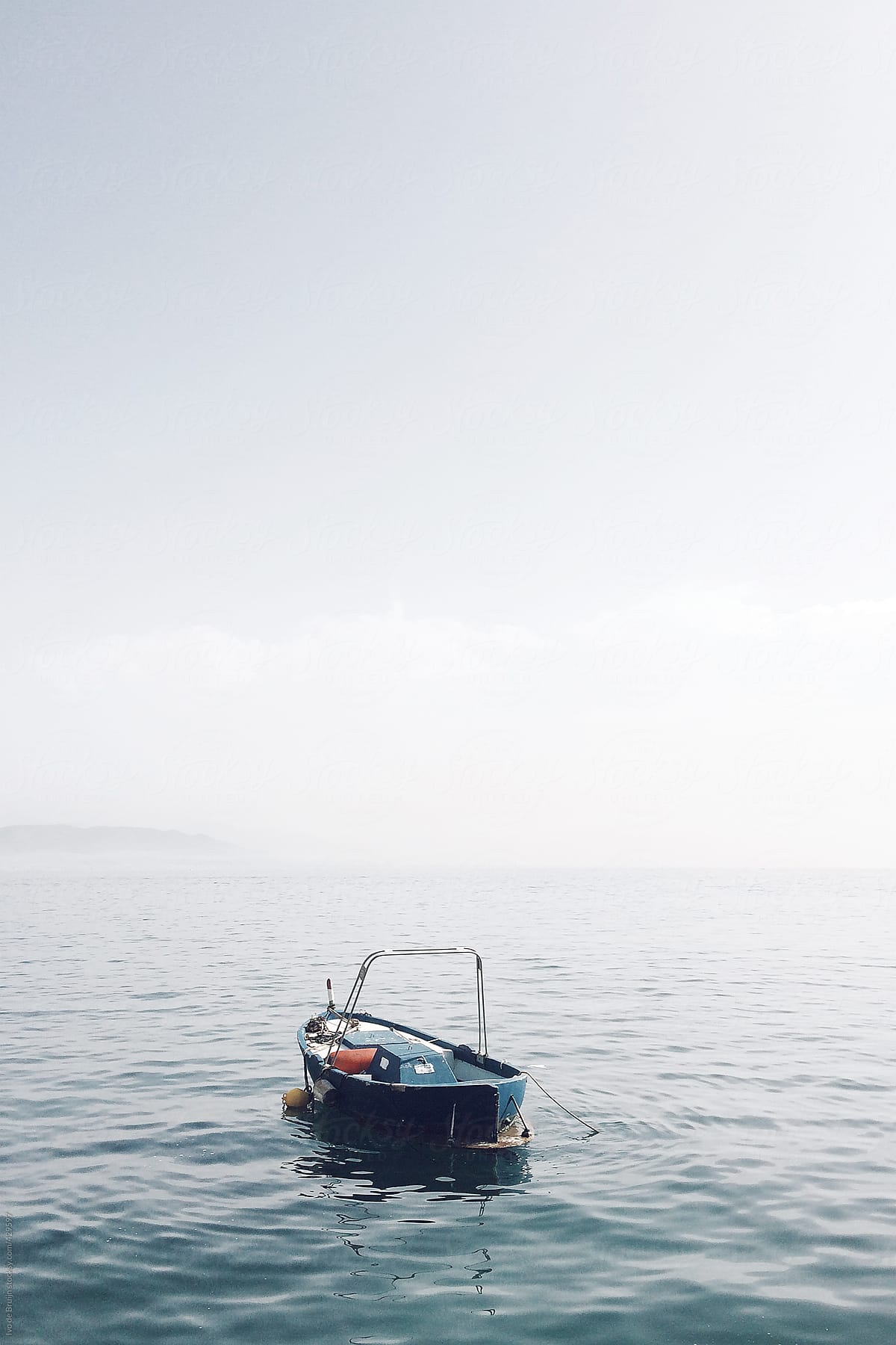 Small classic blue fishing boat floating in the Mediterranean