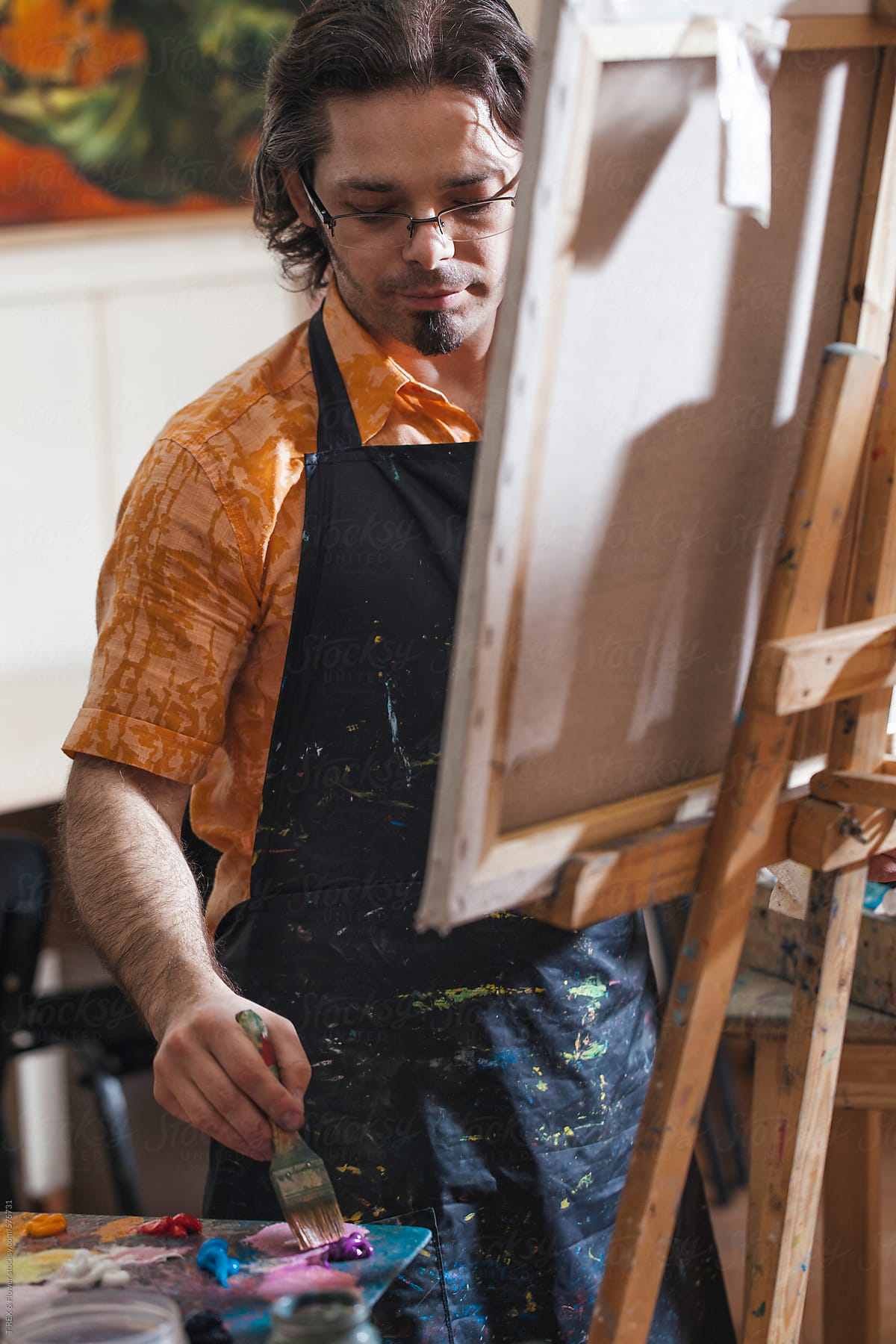 Male artist oil paining in studio