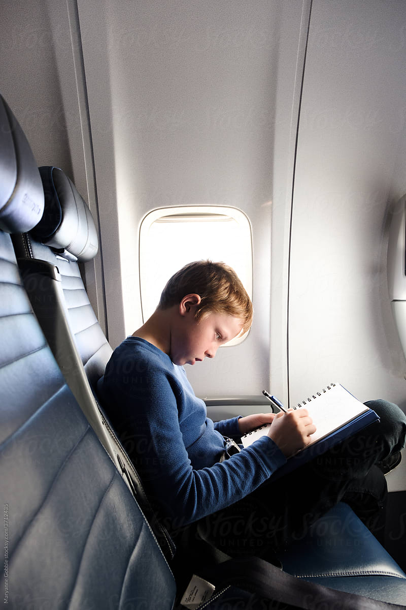 Child Drawing in Notebook During Travel