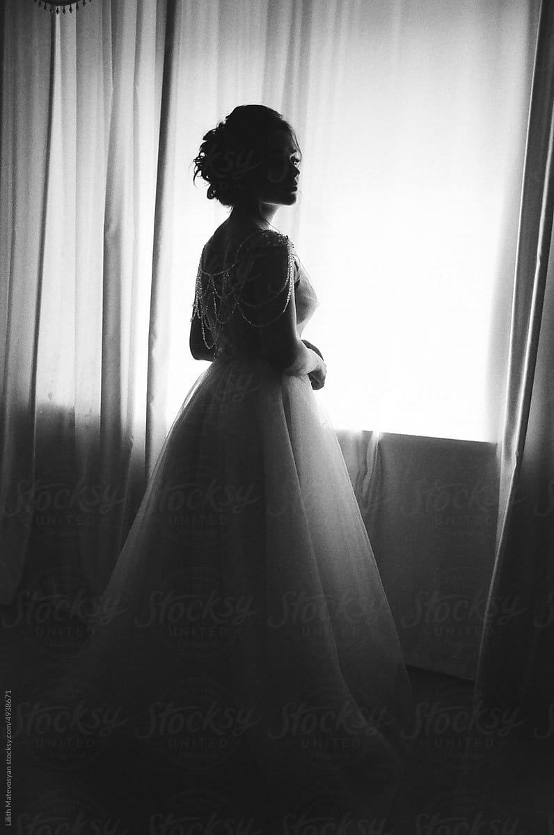 A silhouette of a bride in her room