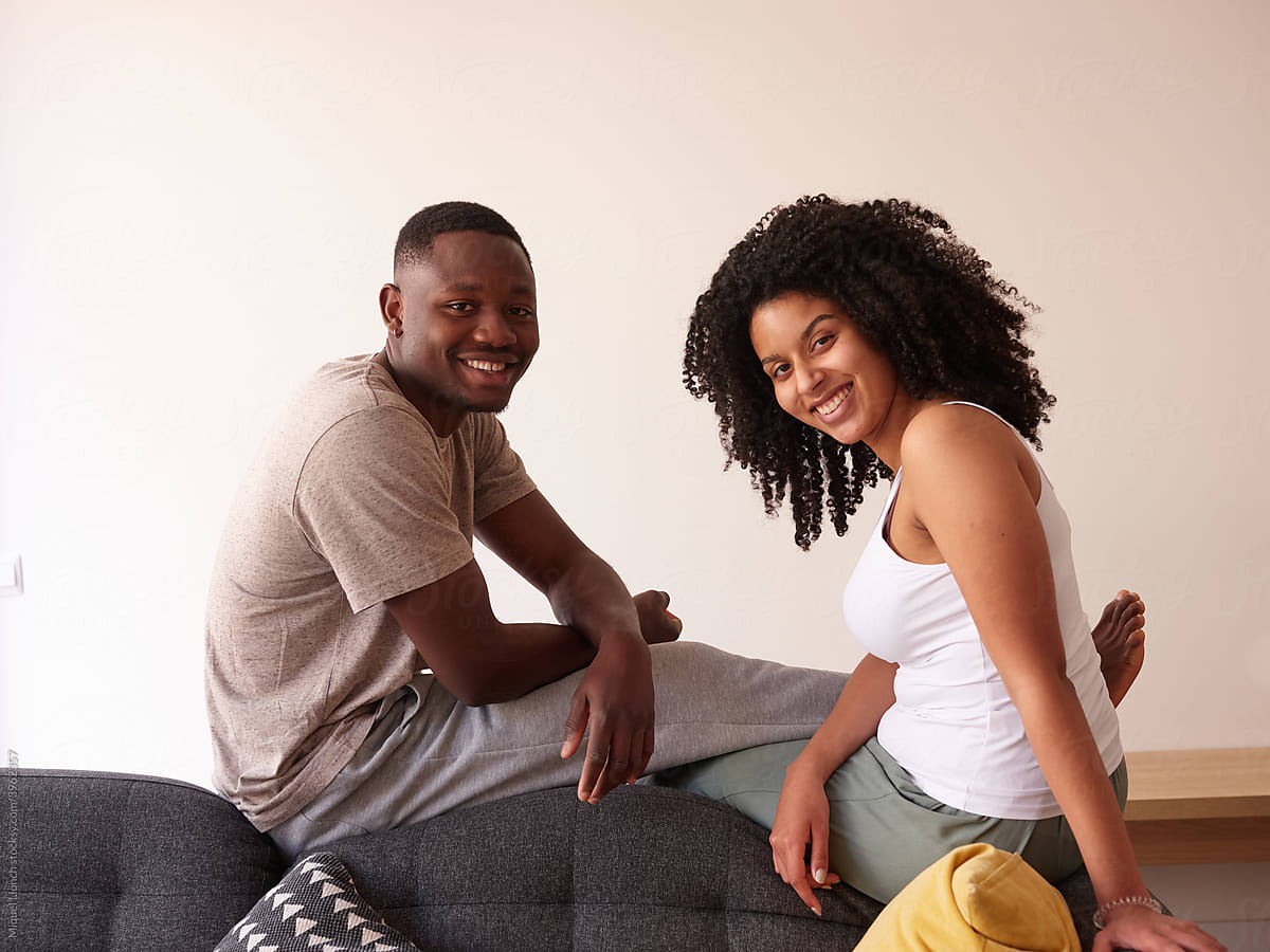 Smiling Black couple on couch.