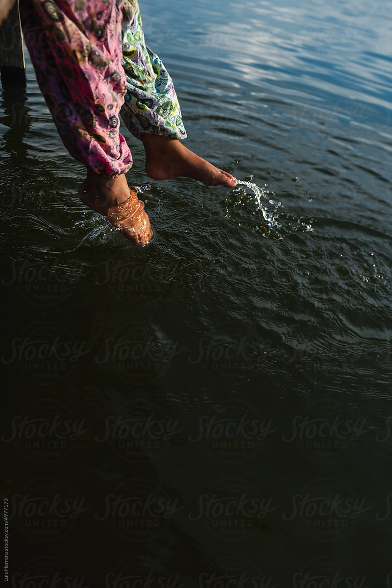 woman legs splashing on water