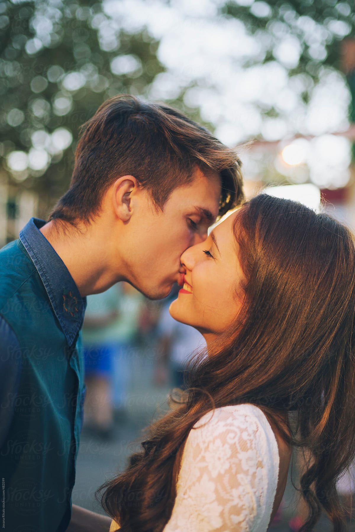 Young couple kissing at the carnival