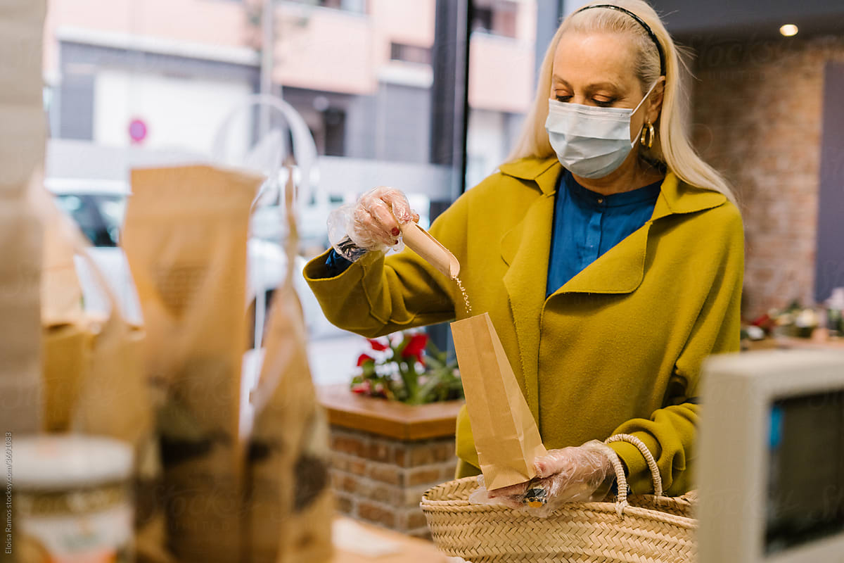 Close-up of senior woman saving seeds in a paper bag