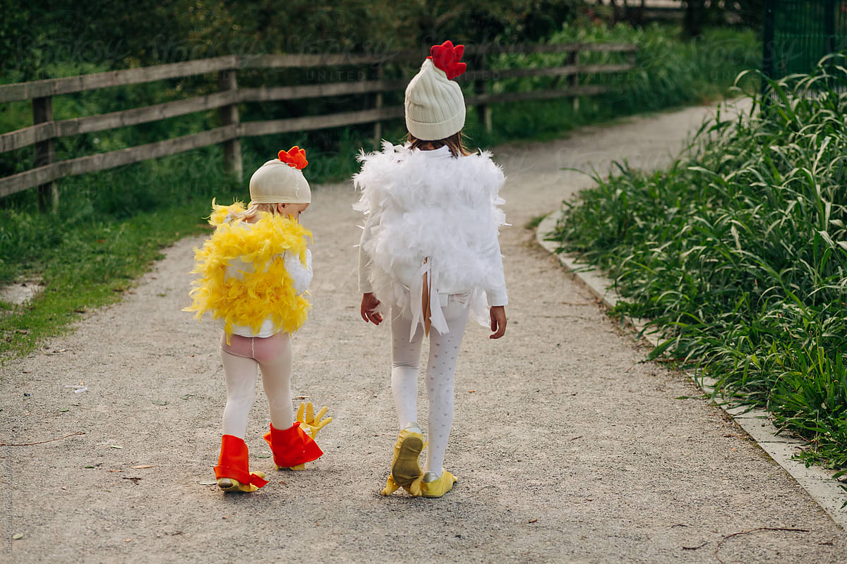 two kids walking in a chicken costume
