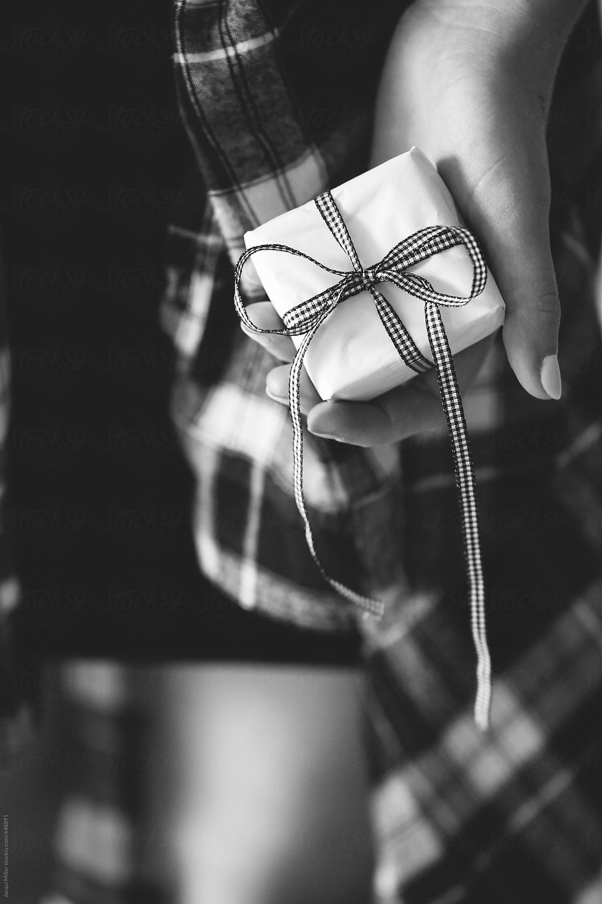 Black and white of female hand holding a small gift