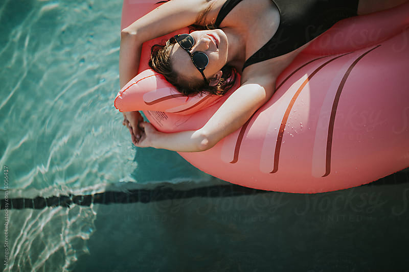 A Girl on a Swan Inflatable Floatie in a Pool in the Summer - Vibes
