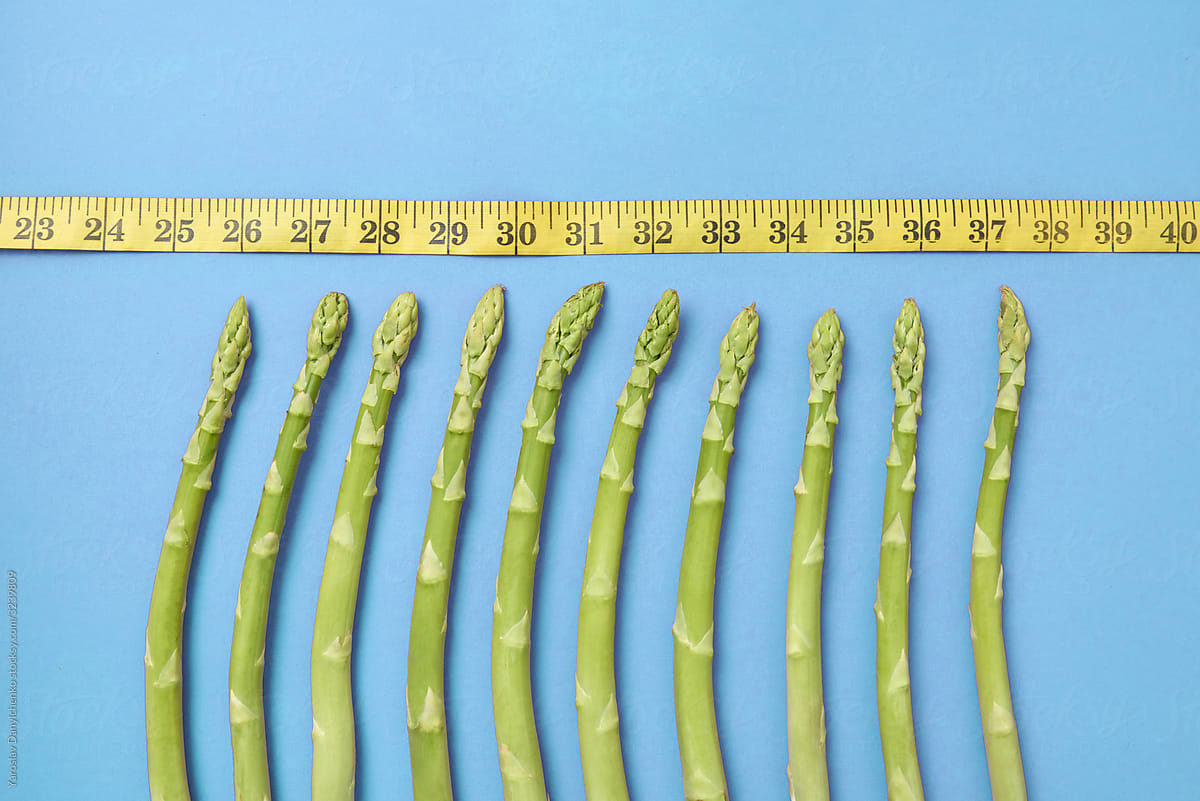 Natural asparagus spears and measuring tape.