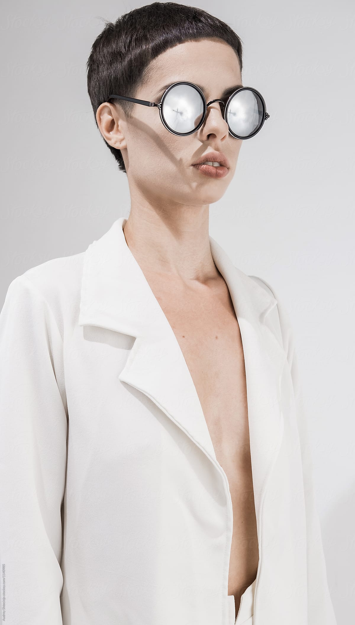 Minimalist fashionable portrait of female model with sunglasses.