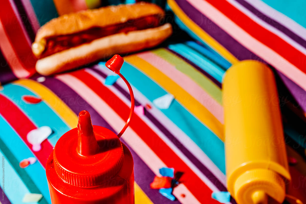 squeeze bottles with ketchup and mustard, and hotdog on an armchair