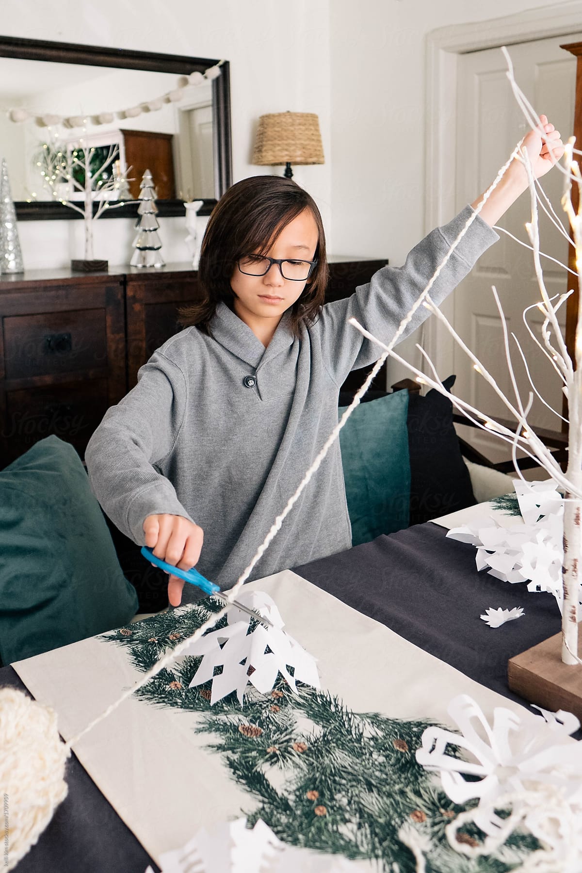 Young boy makes paper snowflakes