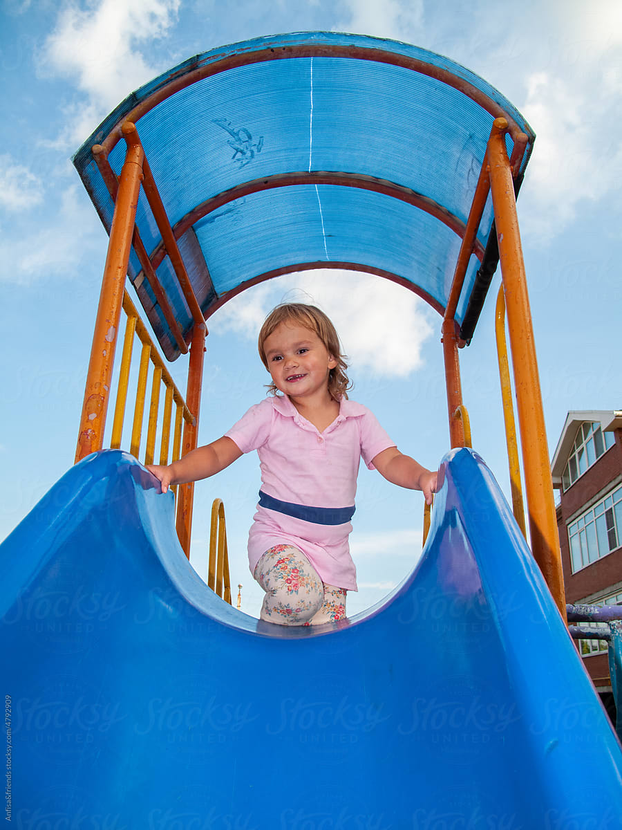 cute girl on playground slide