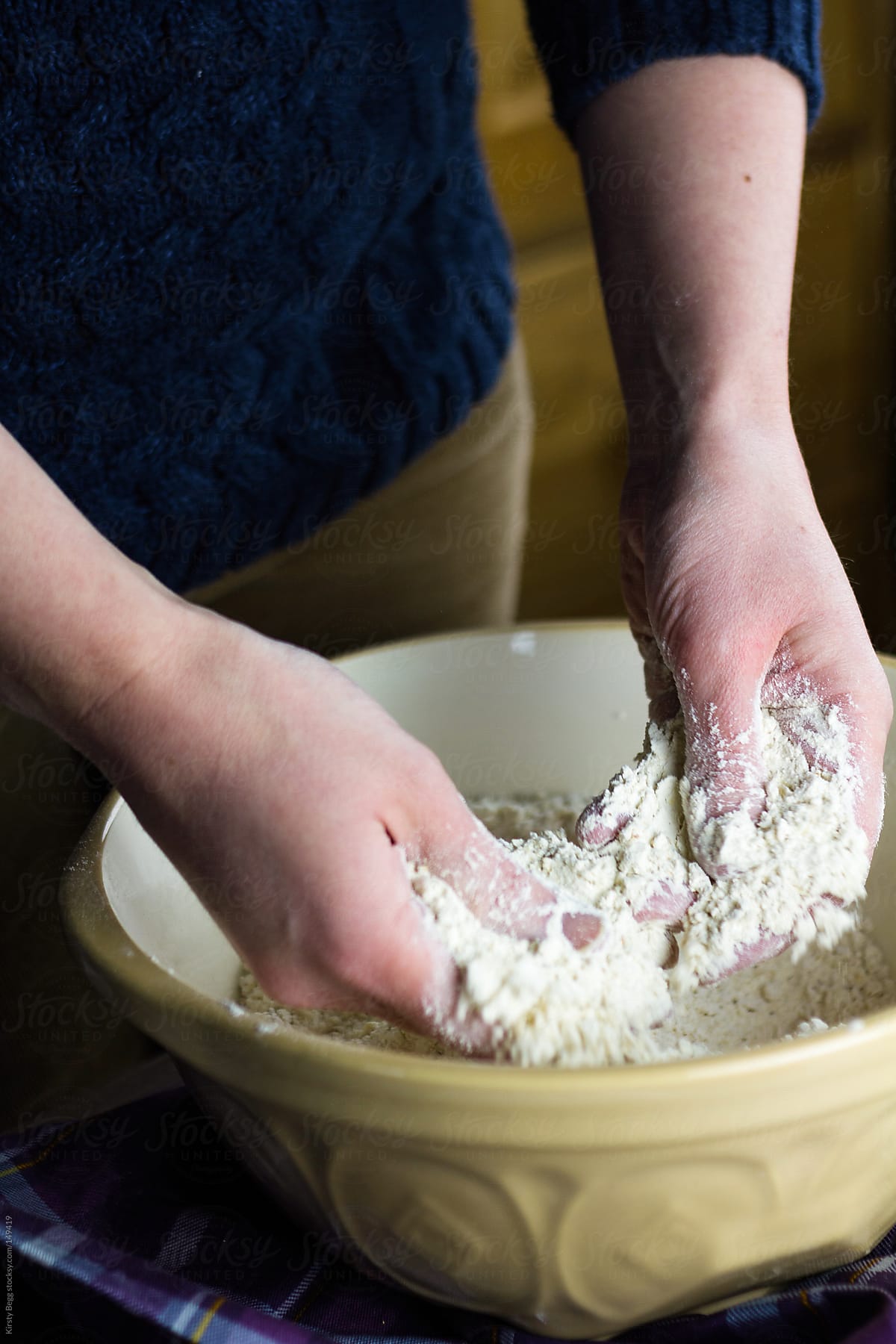 Woman rubbing in butter to flour