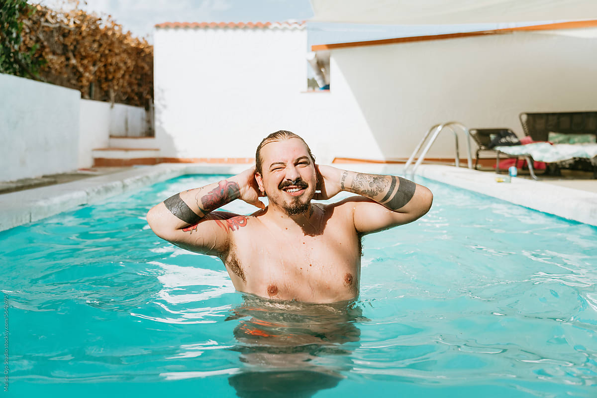 Plus-sized man covered in tattoos in the pool