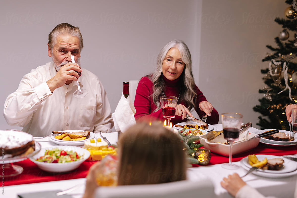 drink red wine grandparents eating Xmas dinner artificial tree
