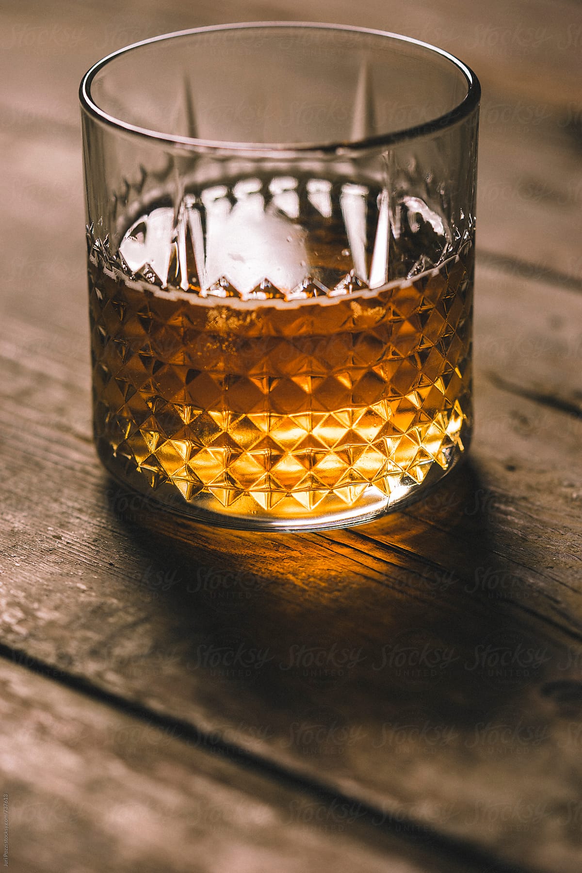 a glass of liquor on a wooden table