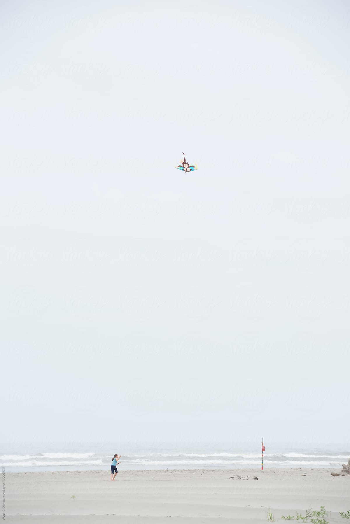 Girl Flying A Kite On The Beach
