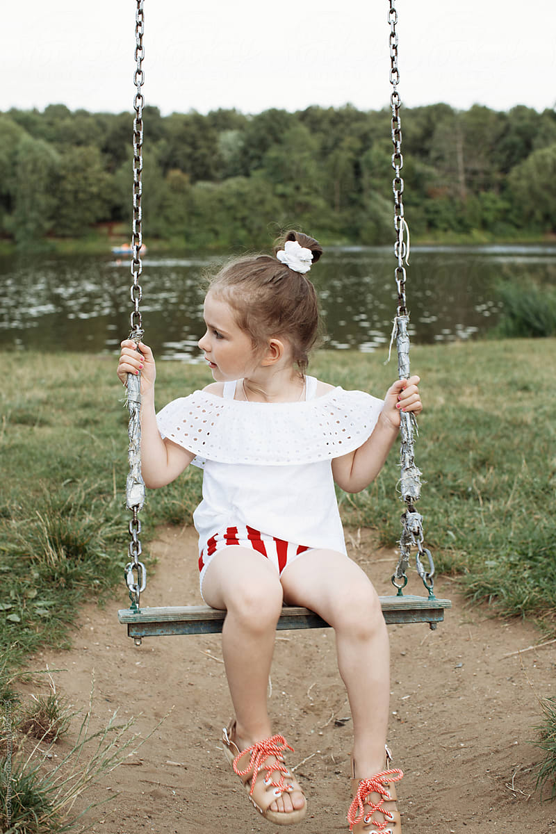 little, cute girl swings on a swing