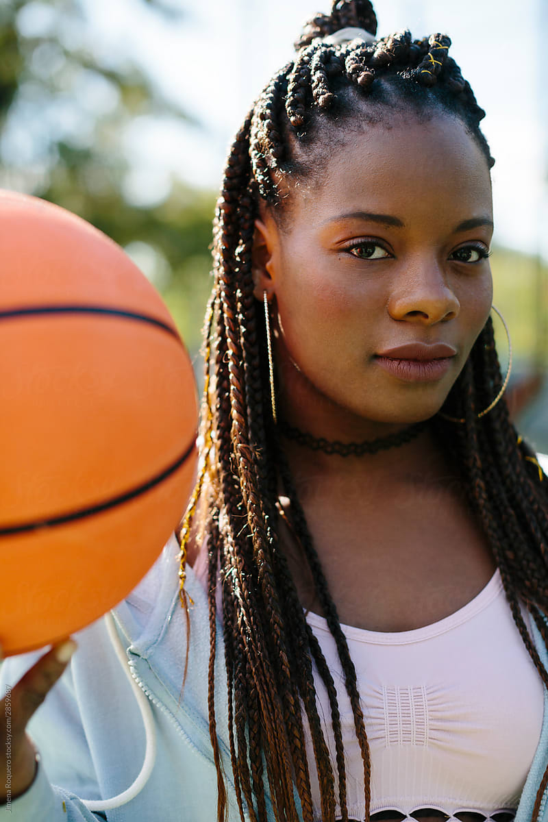 Young woman with basketball ball looking at camera