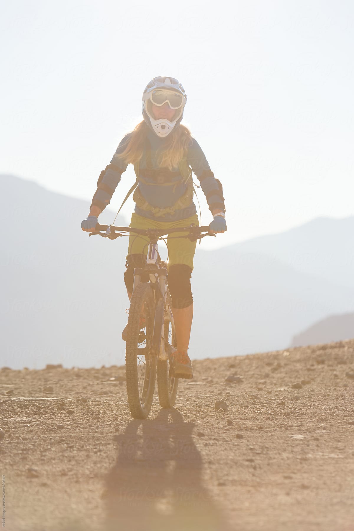 Young woman with helmet and backpack riding mountain bike