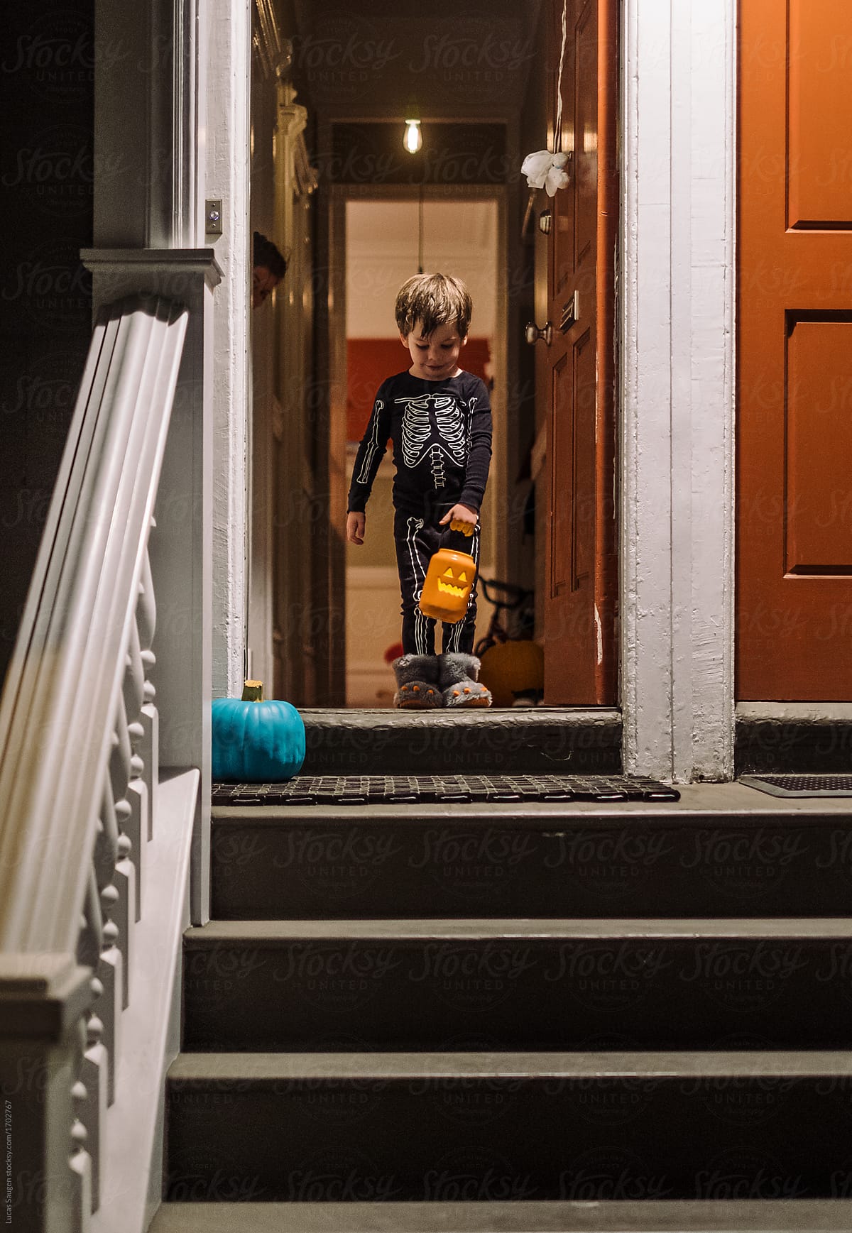Boy with jack-o-lantern basket on doorstep