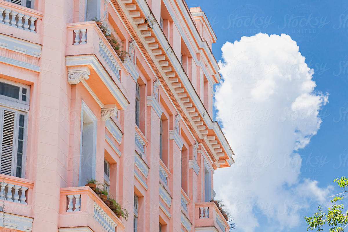 Retro pink building with clouds in the background