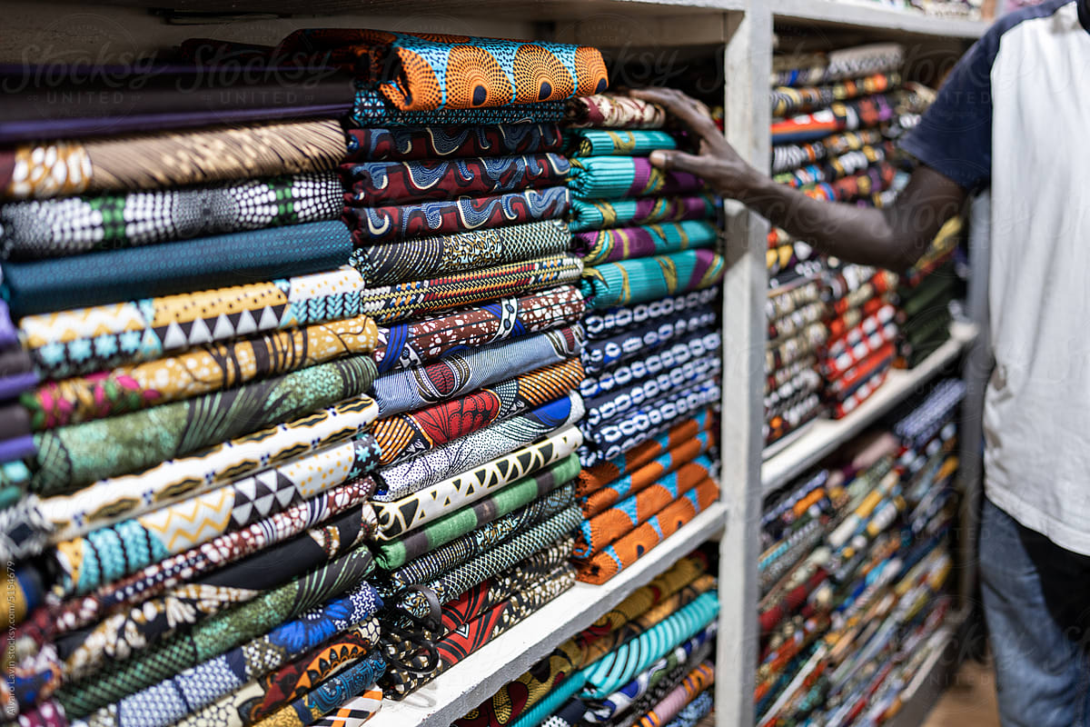 unrecognizable man showing fabrics in textile store