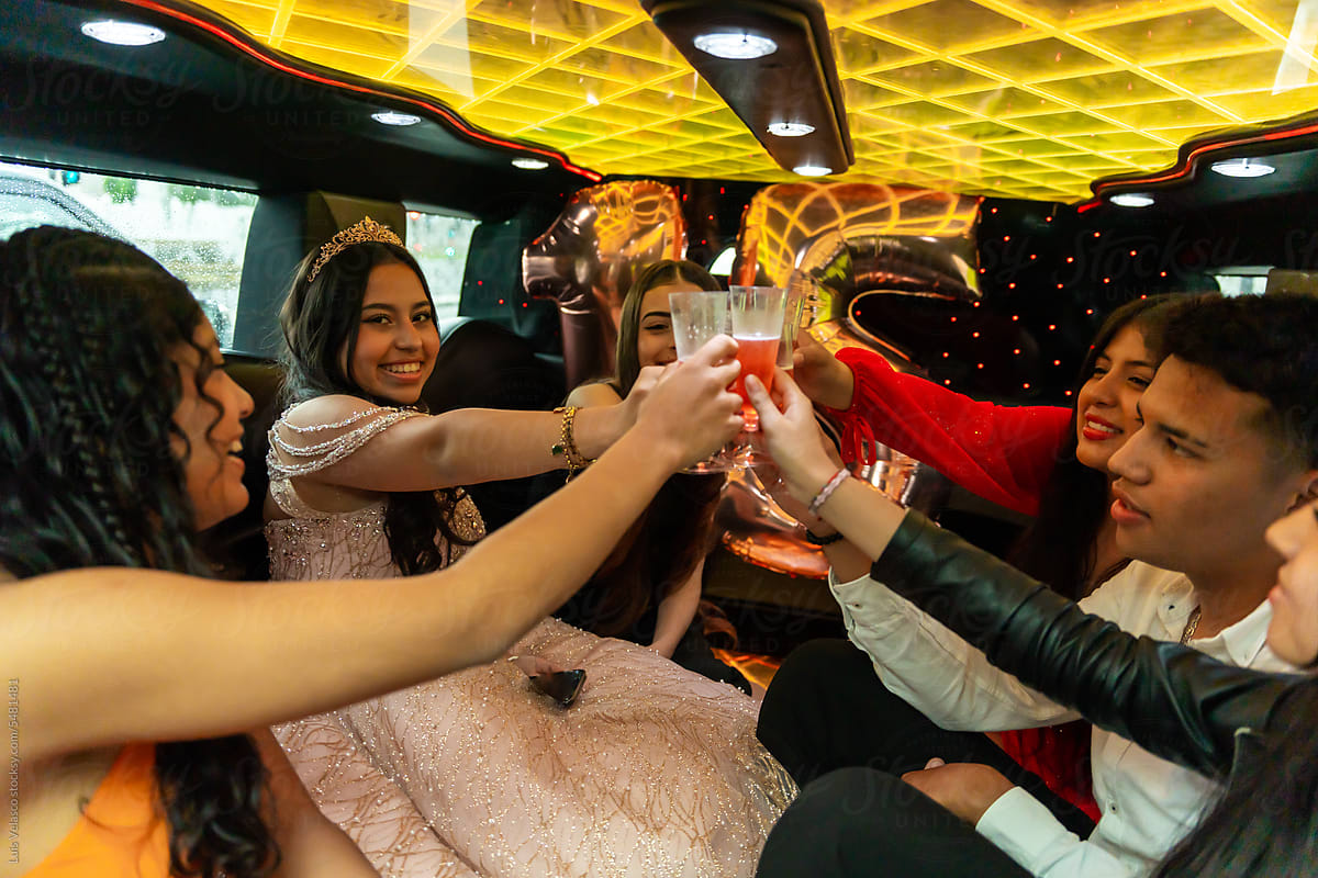 Quinceanera Toasting With Friends On Her Birthday In A Limousine.